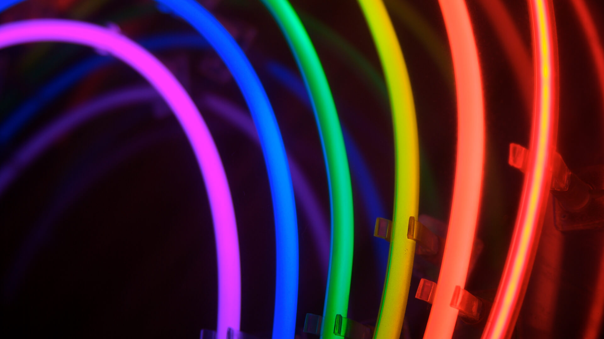 Neon coloured glow sticks in a black background.